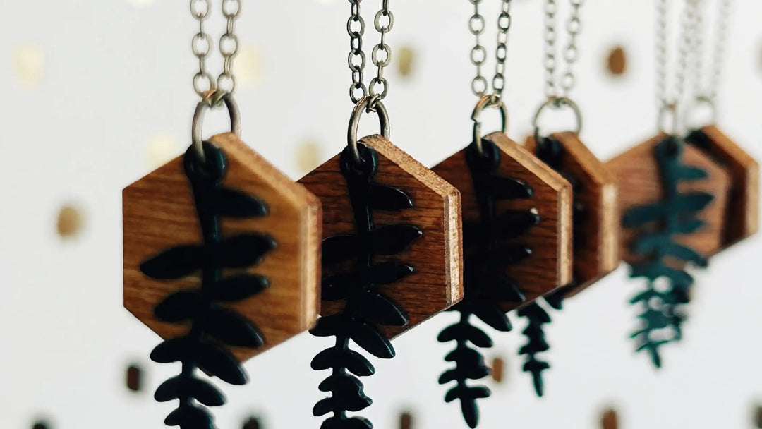 multiple Cascade Necklaces hanging in front of a white BG with gold dots